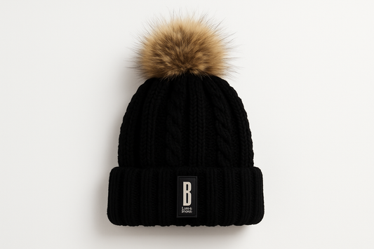 Professional product photo of black knit beanie with fur pom pom